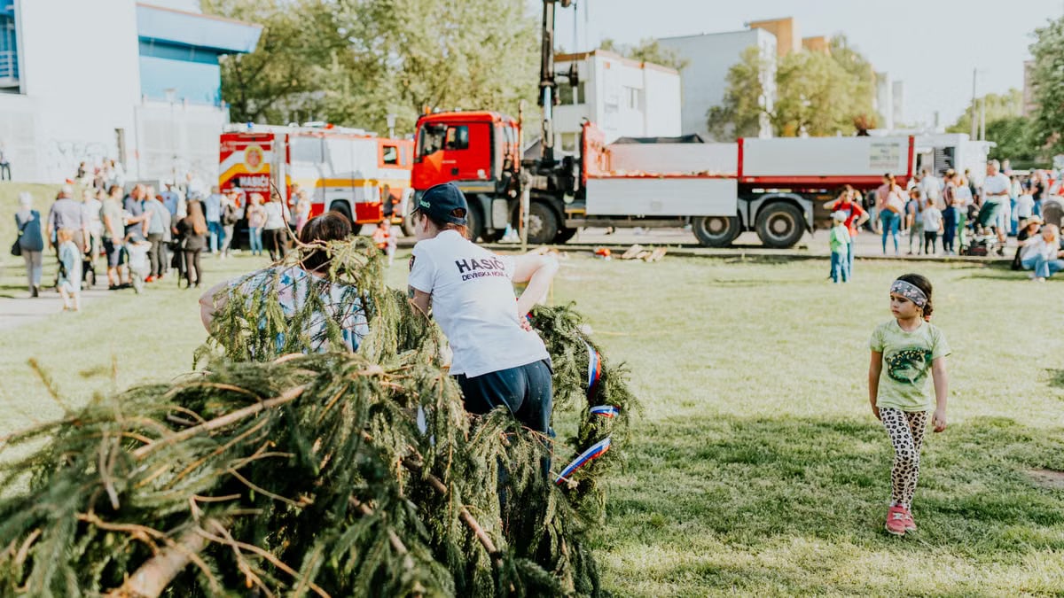 A lively outdoor community event featuring fire trucks, families, and a festive atmosphere.